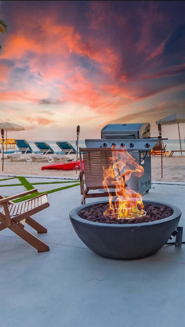 patio terrace at dusk featuring an outdoor fire pit