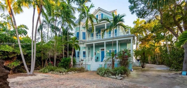 beach home featuring a porch and a balcony