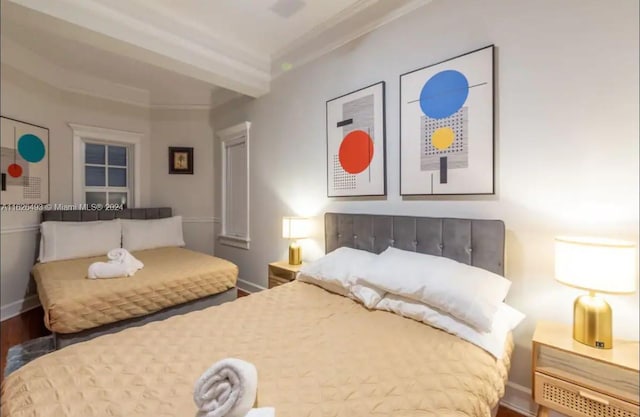 bedroom with wood-type flooring and beam ceiling