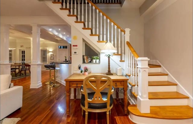 stairway featuring hardwood / wood-style flooring and ornate columns