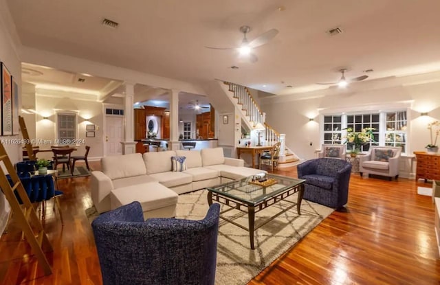 living room with decorative columns, wood-type flooring, washer / dryer, and ceiling fan