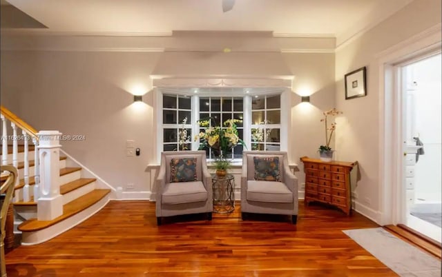 living area with ornamental molding and wood-type flooring