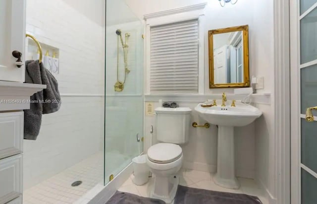 bathroom featuring sink, an enclosed shower, and toilet