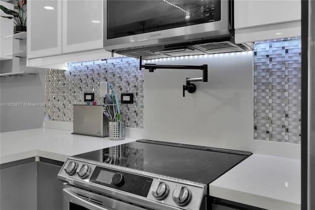 kitchen featuring white cabinetry, backsplash, and stainless steel appliances