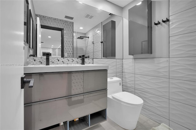 bathroom with tile walls, tile patterned floors, toilet, and vanity