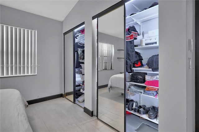 walk in closet with light hardwood / wood-style flooring