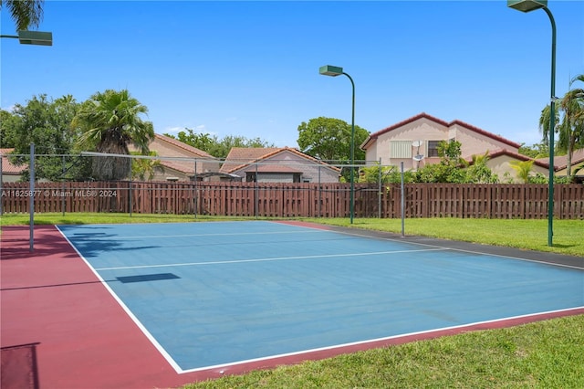 view of tennis court with a lawn