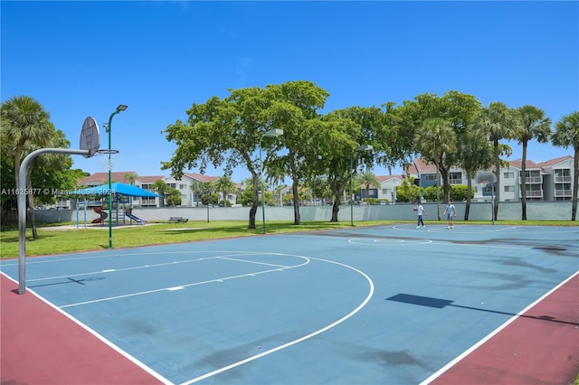 view of basketball court featuring a yard and a playground