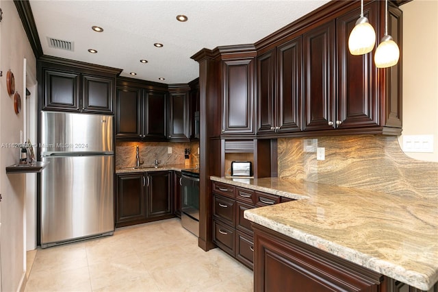 kitchen with freestanding refrigerator, visible vents, light stone countertops, and stove