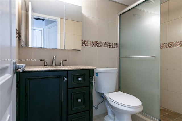 bathroom with vanity, tasteful backsplash, tile walls, an enclosed shower, and toilet