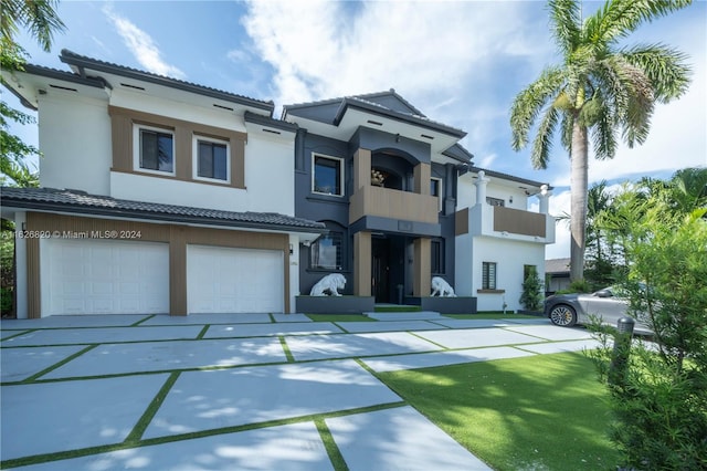 view of front of property featuring a garage and a balcony