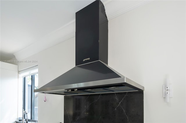 details featuring crown molding and wall chimney exhaust hood