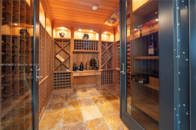 wine room with wood ceiling and tile patterned flooring