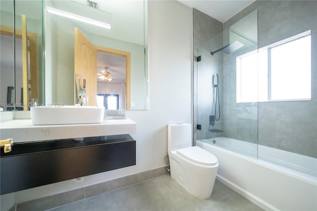 full bathroom with tile patterned flooring, tiled shower / bath, toilet, vanity, and ceiling fan