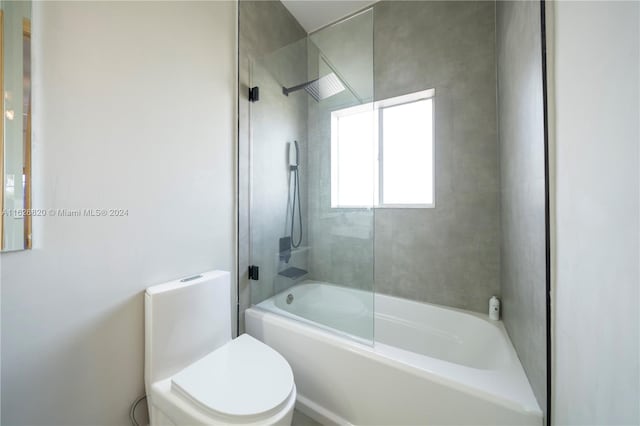 bathroom featuring shower / bath combination with glass door and toilet