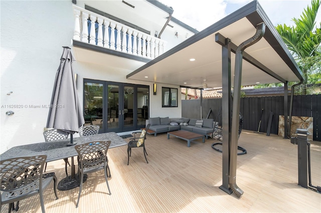 wooden deck featuring an outdoor living space and french doors