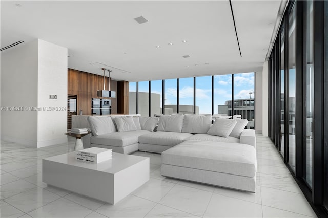 living room featuring wooden walls, baseboards, and a wall of windows