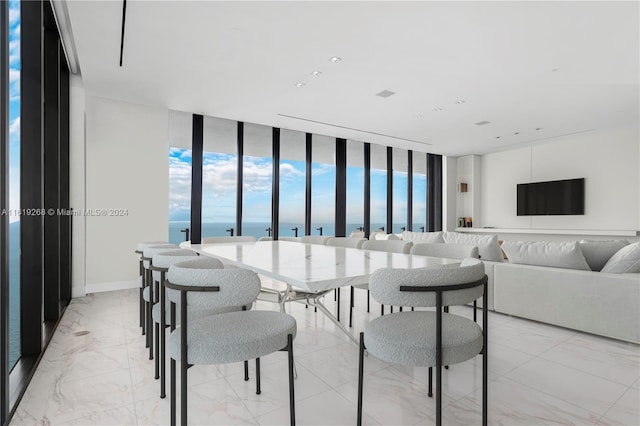 dining area featuring baseboards and a wall of windows