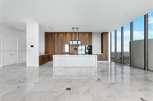 kitchen with a kitchen island, light countertops, a wall of windows, modern cabinets, and pendant lighting