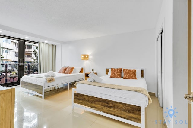 bedroom featuring a textured ceiling, access to outside, and tile patterned flooring