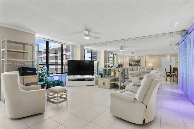 tiled living room with ornamental molding, ceiling fan, a textured ceiling, and floor to ceiling windows