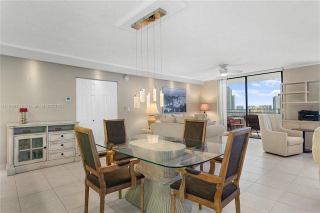 tiled dining space with ceiling fan and a wall of windows