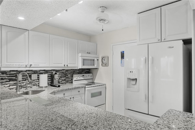 kitchen with sink, backsplash, white cabinetry, light stone counters, and white appliances