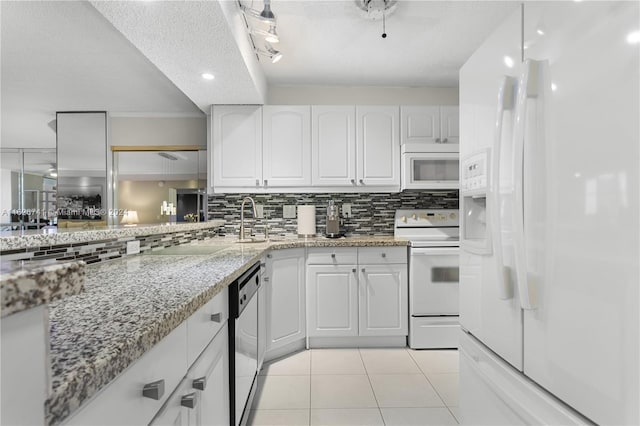 kitchen featuring white appliances, light tile patterned floors, white cabinets, sink, and light stone counters