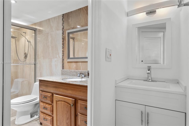 bathroom with toilet, a shower with shower door, and vanity