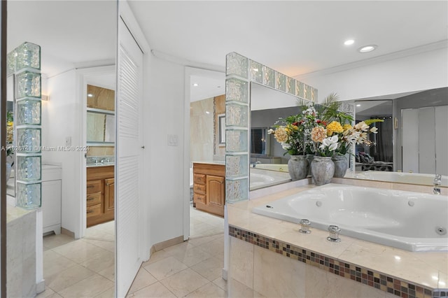 bathroom with crown molding, tile patterned flooring, tiled bath, and vanity