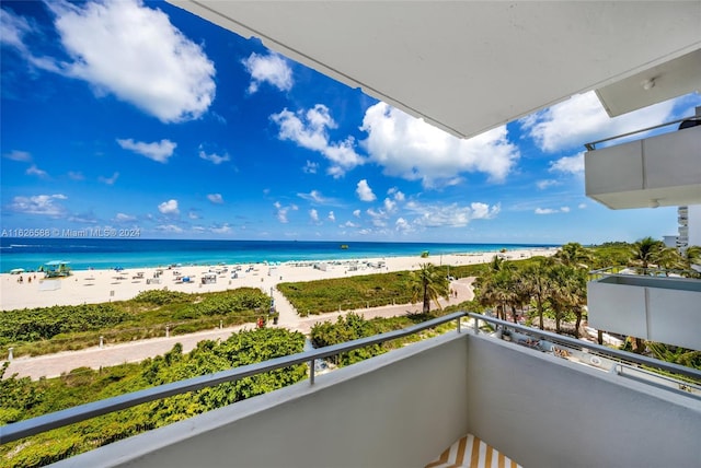 balcony featuring a beach view and a water view