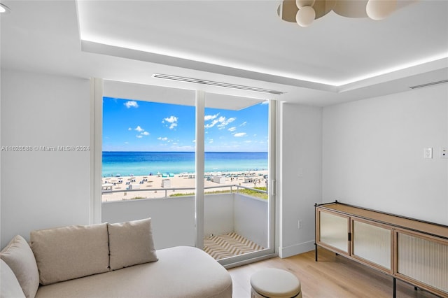 living area featuring visible vents, a water view, and light wood finished floors