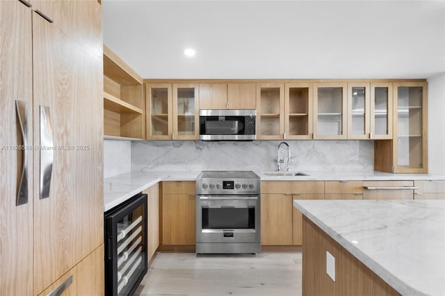 kitchen featuring tasteful backsplash, light stone countertops, wine cooler, stainless steel appliances, and a sink