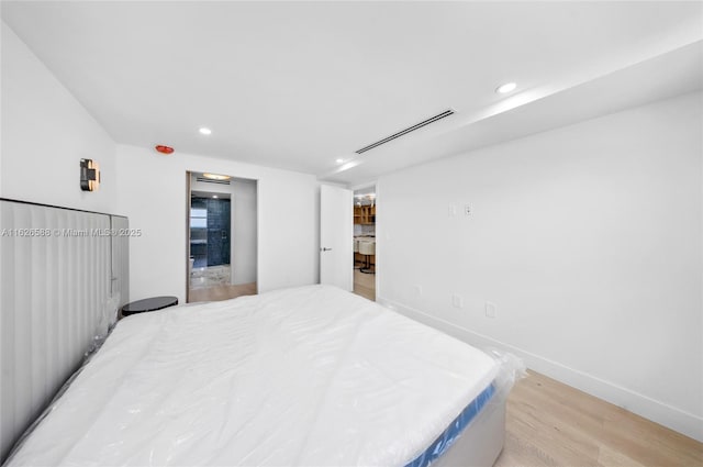 bedroom with recessed lighting, visible vents, baseboards, and light wood finished floors