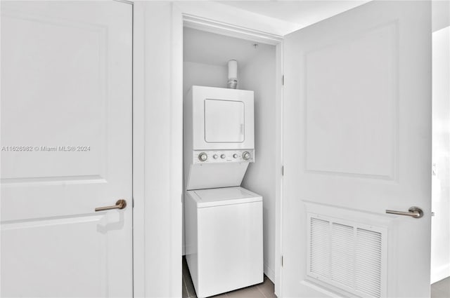 washroom with light tile patterned floors and stacked washer and clothes dryer