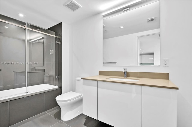 full bathroom with vanity, toilet, tile patterned flooring, and bath / shower combo with glass door