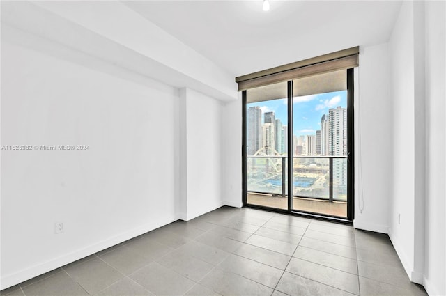 tiled spare room featuring a wealth of natural light and floor to ceiling windows