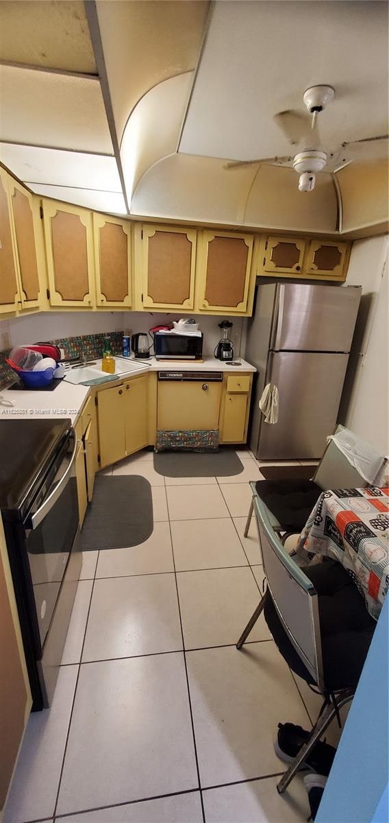 kitchen featuring appliances with stainless steel finishes, ceiling fan, light brown cabinetry, and light tile patterned floors