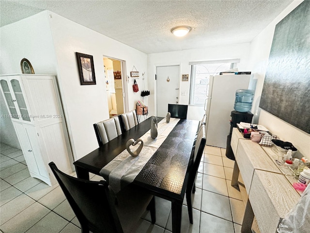 tiled dining room featuring a textured ceiling