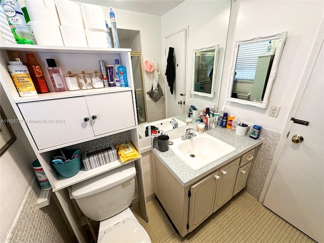 bathroom featuring tile patterned flooring, toilet, and vanity