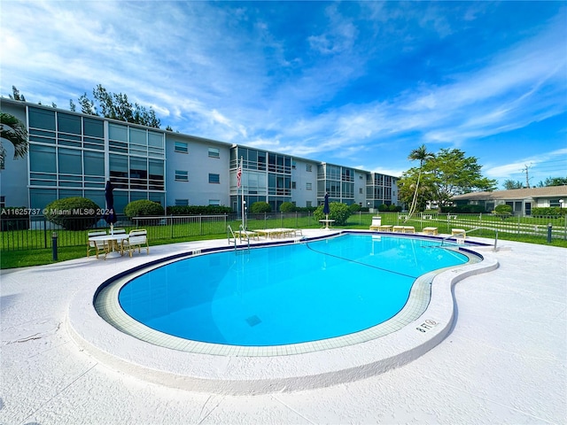 view of pool featuring a lawn