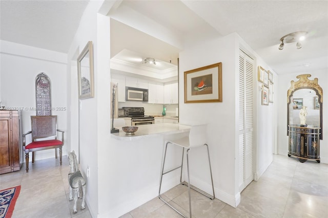 hall with baseboards, a tray ceiling, and light tile patterned flooring