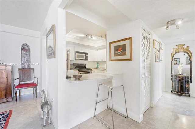 corridor with baseboards, a raised ceiling, and light tile patterned floors