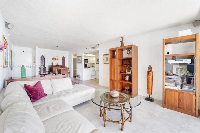 living area featuring light tile patterned floors and visible vents