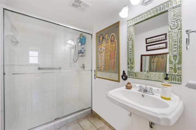bathroom featuring tile patterned floors, visible vents, a shower stall, and a sink