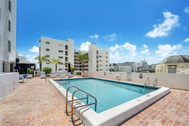 community pool featuring a view of city and a patio area