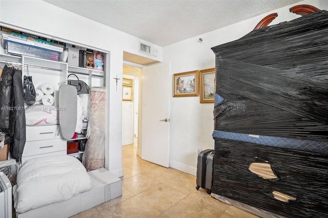 bedroom featuring tile patterned flooring, visible vents, and baseboards