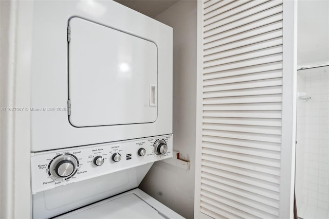 clothes washing area with stacked washing maching and dryer and laundry area