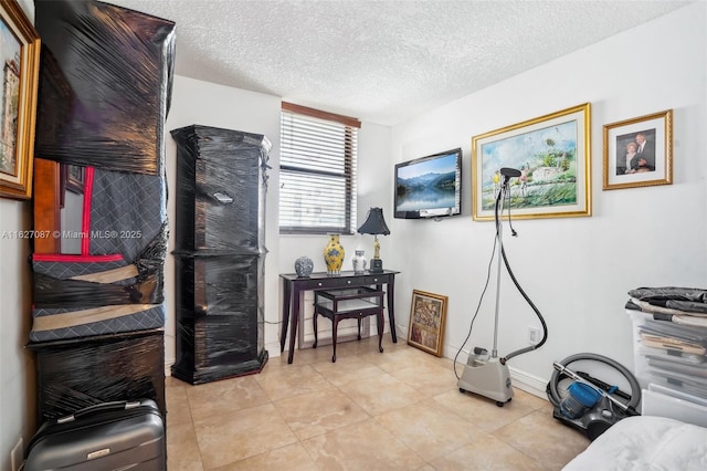 interior space with baseboards, a textured ceiling, and light tile patterned floors