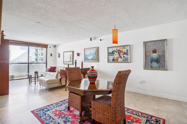dining space with a textured ceiling, baseboards, and tile patterned flooring